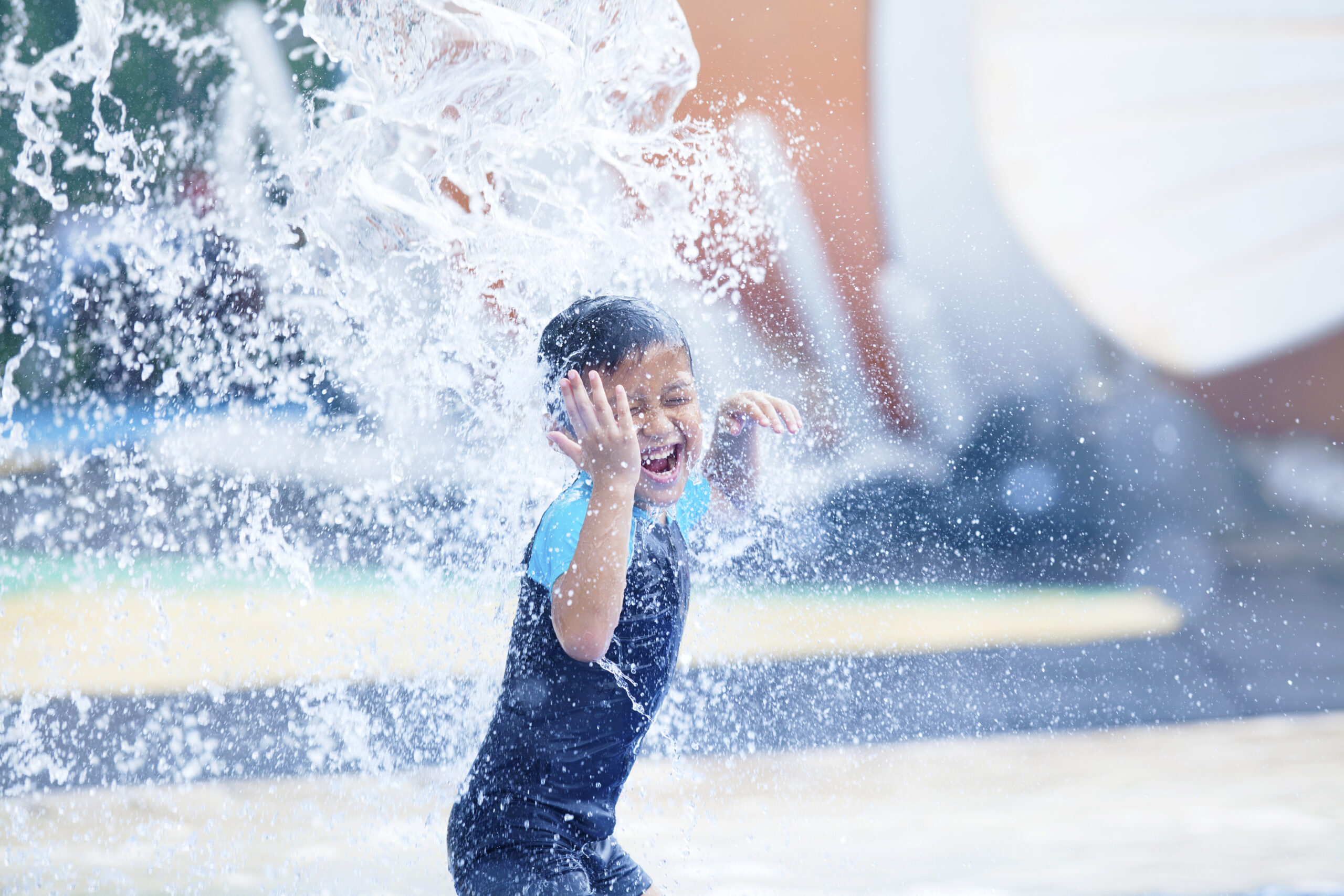 Young boy playing in a pool fountain