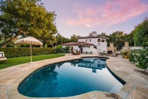 a large home with a large swimming pool in front of it